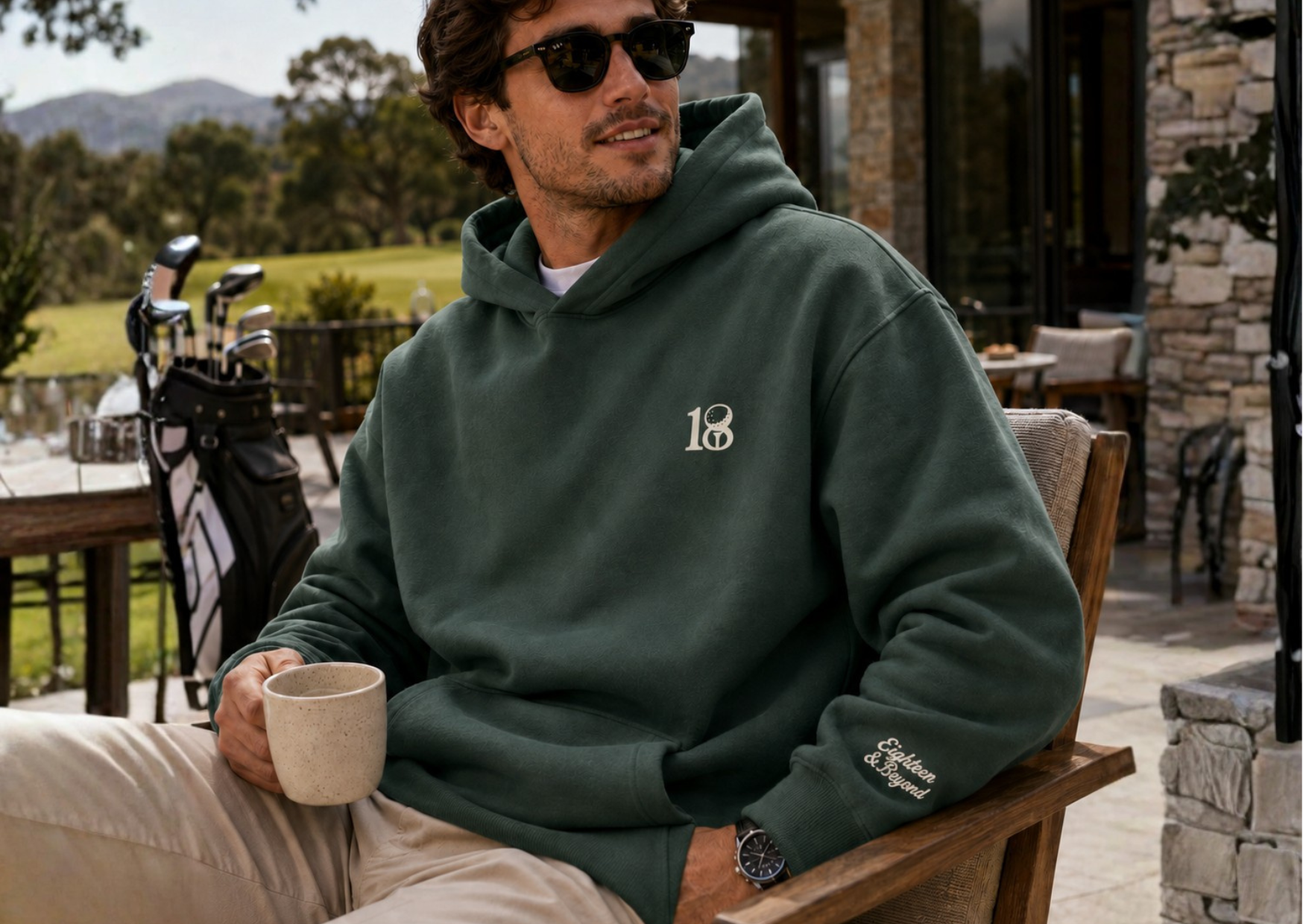 Woman in the clubhouse wearing Eighteen and Beyond cream hoodie with embroidered 18 logo